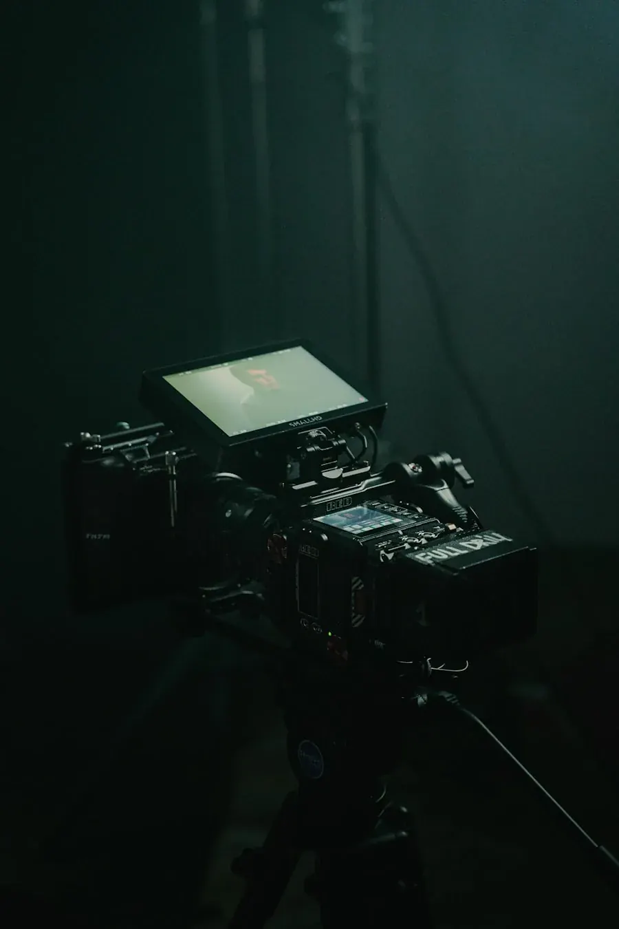 Câmera de cinema montada em tripé dentro de um estúdio escuro